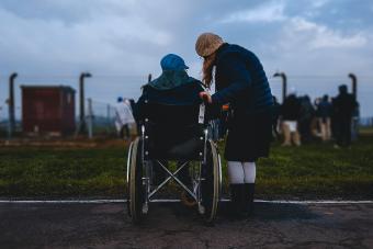 person in wheelchair accompanied by friend/family member