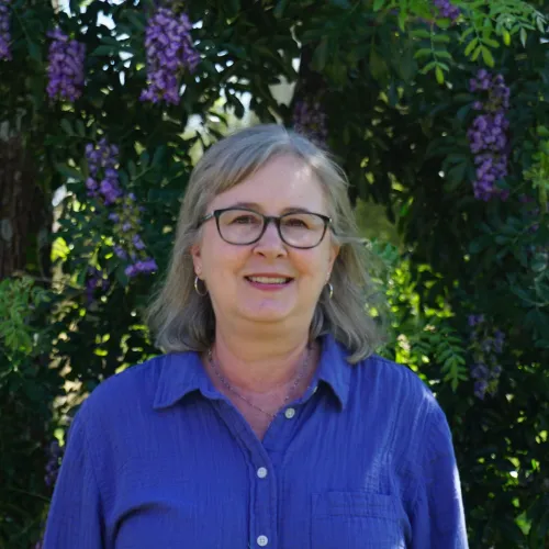 headshot of Jennifer with Purple flowered tree in background