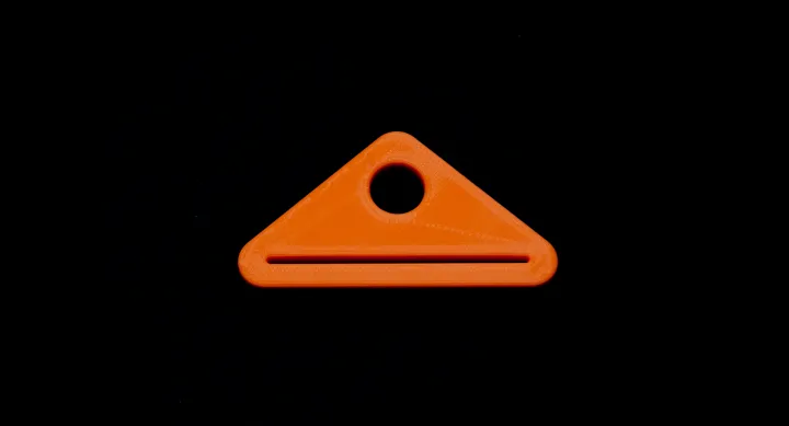 Orange toothpaste squeezer, with thin rounded opening at the bottom