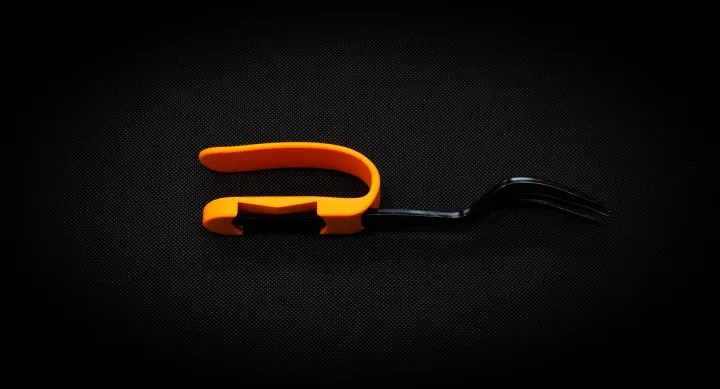 Orange utensil palm cuff that fits the shape of the hand, and has two openings to secure utensil